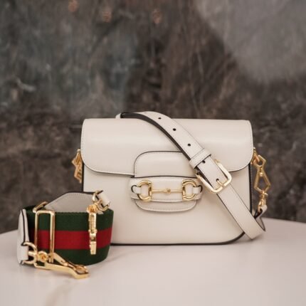 Horsebit 𝟏𝟗𝟓𝟓 Mini Handbag The white n detachable double shoulder strap adds a mix-and-match look to this vintage-inspired collection. n This mini handbag comes with two different straps, one in the same color leather for an understated elegance, and one in red and green webbing for a strong brand identity. The bag is crafted from double G monogrammed canvas with white leather piping. nSize: 20.5*14.5*5cmn🔍: 6585730031