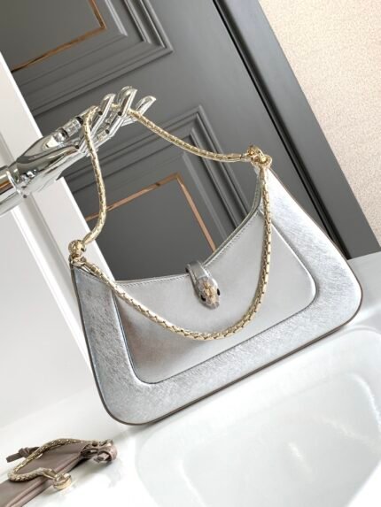 The new Chip Editionn BV*GAR🤍n SERPENTI BAIA Collection Small Shoulder Bagn🔸 is crafted in silver-toned textured calf leather, showcasing metallic textures and delicate veining, reminiscent of the beautiful inclusions of a raw diamondn adorned with the iconic Snakehead magnetic clasp🐍, whose seductive Enchanting scales n🔹 features a single compartment with top zipper closure, an interior open flat pocket, and BULGARI metal logo on the back n🔺 with  2 ⃣️ detachable snake thick chain and additional chain device to extend the shoulder strap at your will, allowing for multiple wearing styles. nWith upgraded gold gift box🎁nSize:27.5*18*4.5Cm2932080801n